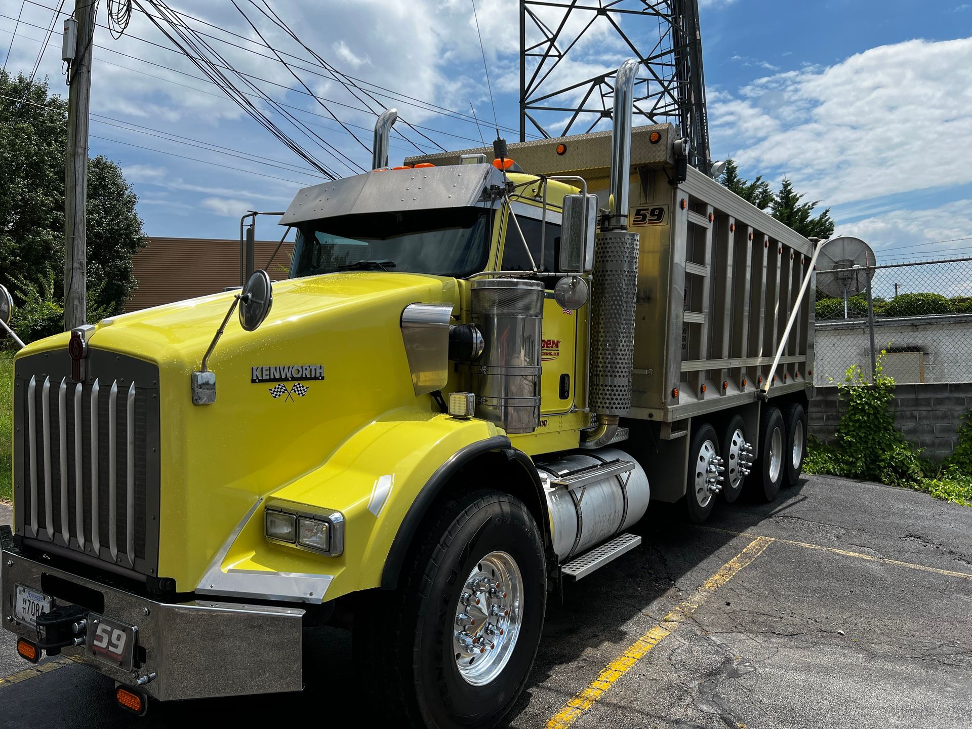 A yellow dump truck is parked in a parking lot.