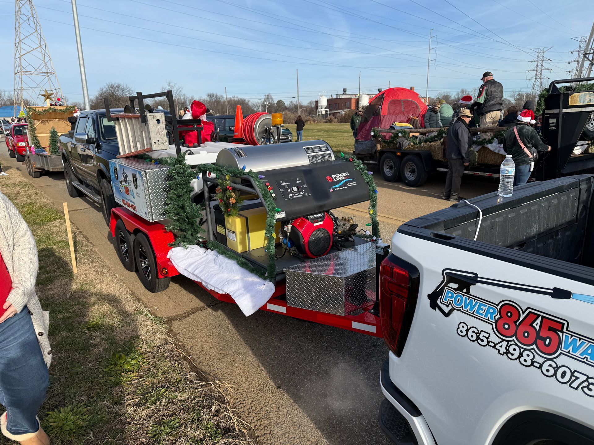 A truck is pulling a trailer with a christmas tree on it.