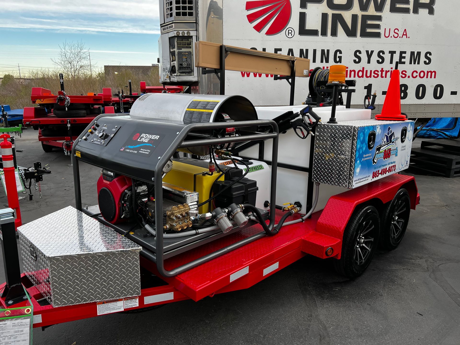 A power line cleaning systems trailer is parked in a parking lot. 865 Power Wash equipment