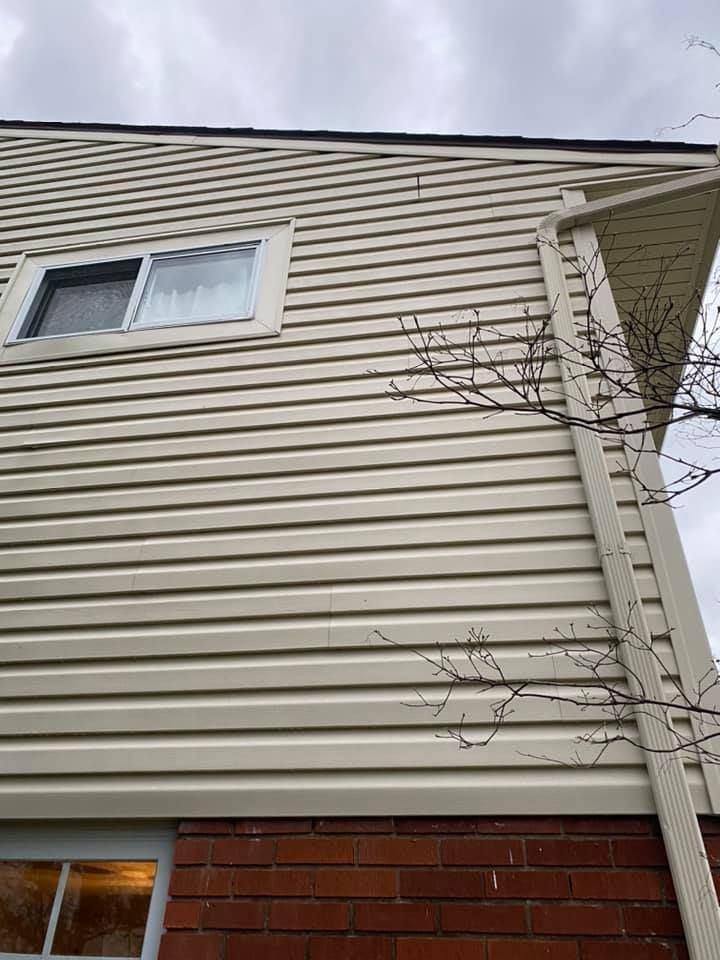 The side of a house with white siding and a window.