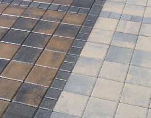 A close up of two different colored bricks on a sidewalk.