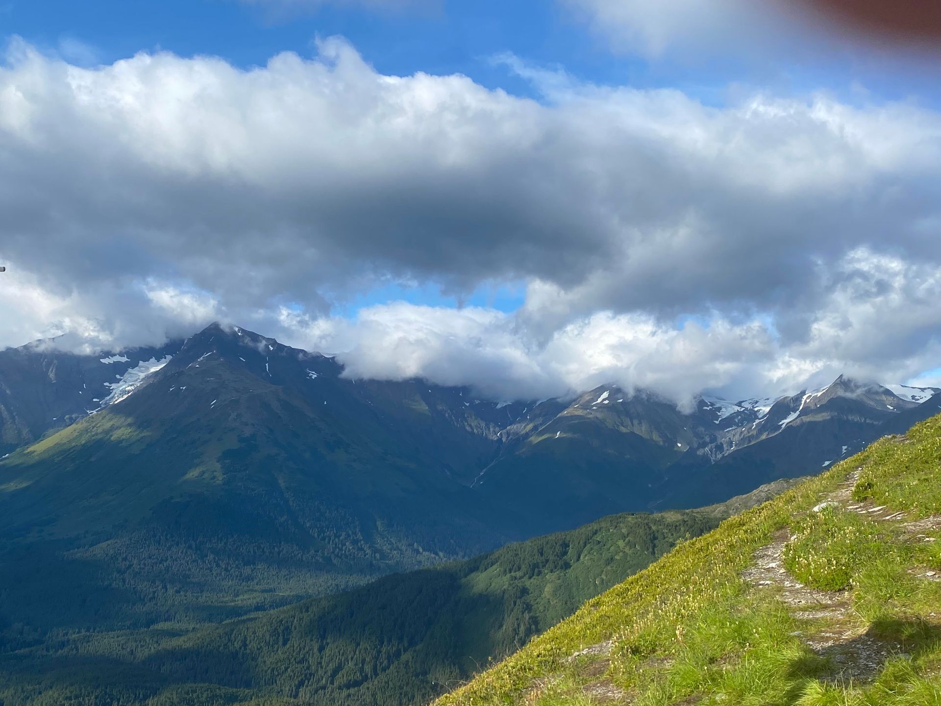 A view of a mountain range with clouds in the sky