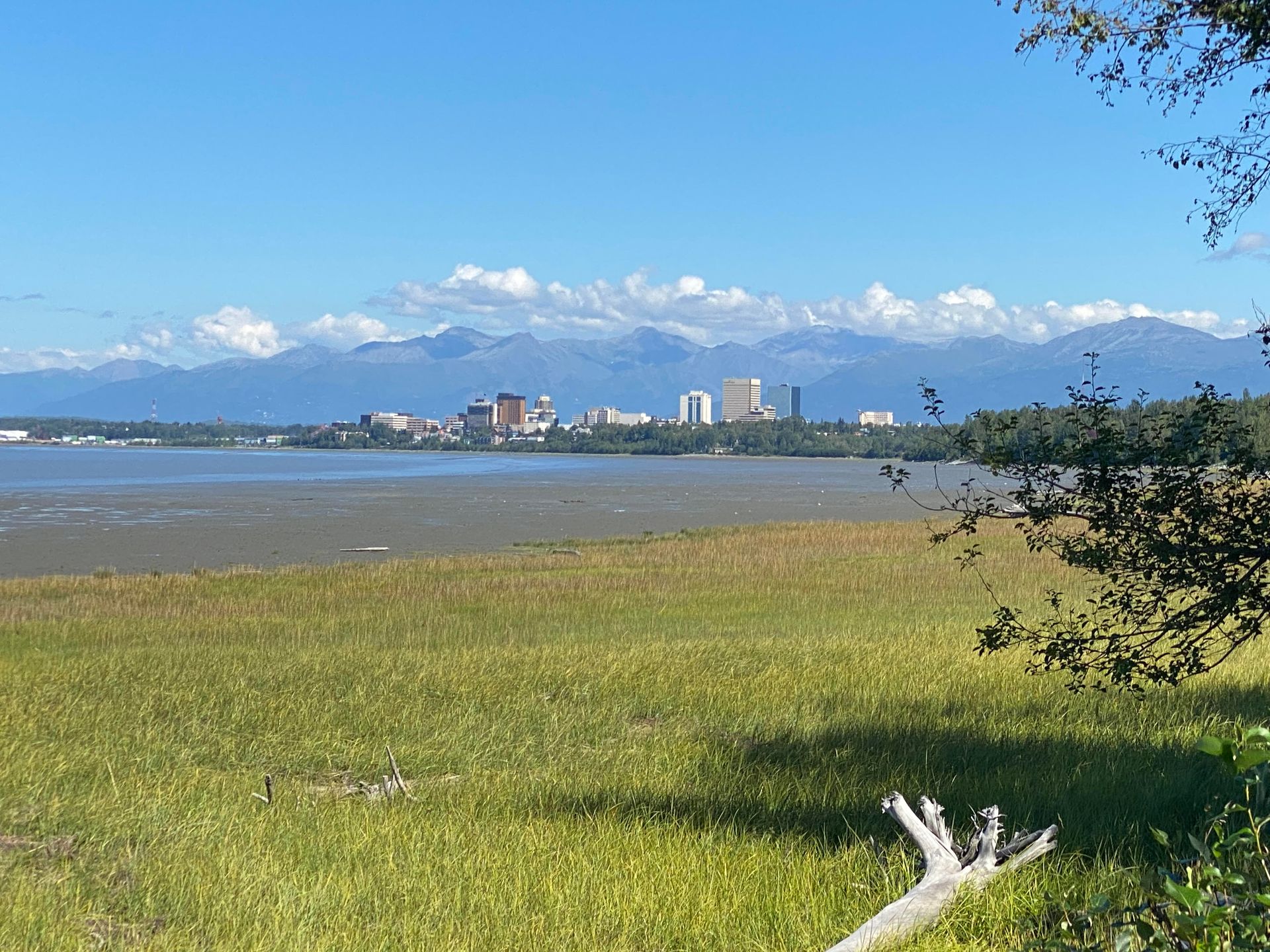A large body of water with mountains in the background and a city in the distance