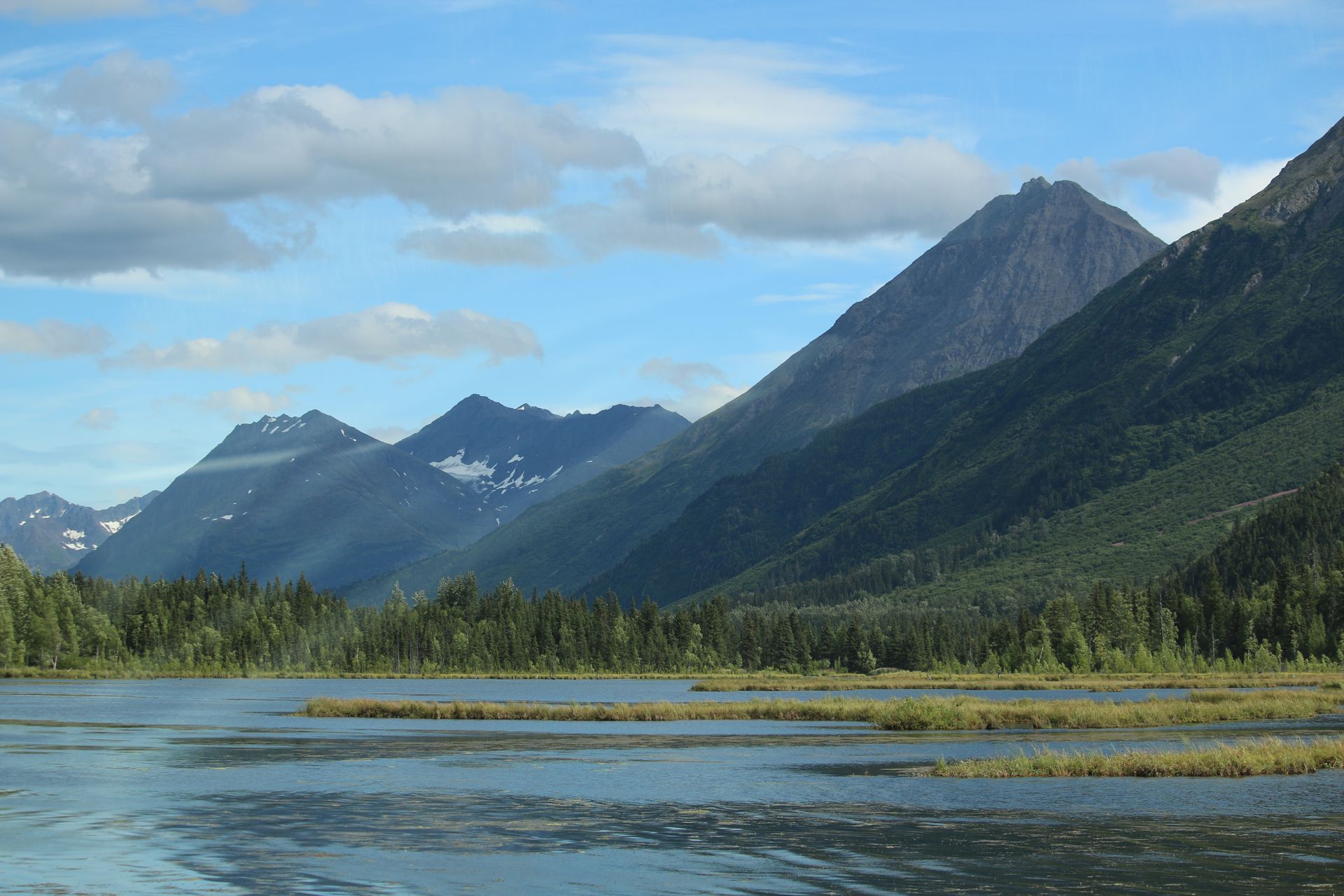 A lake with mountains in the background and trees on the shore