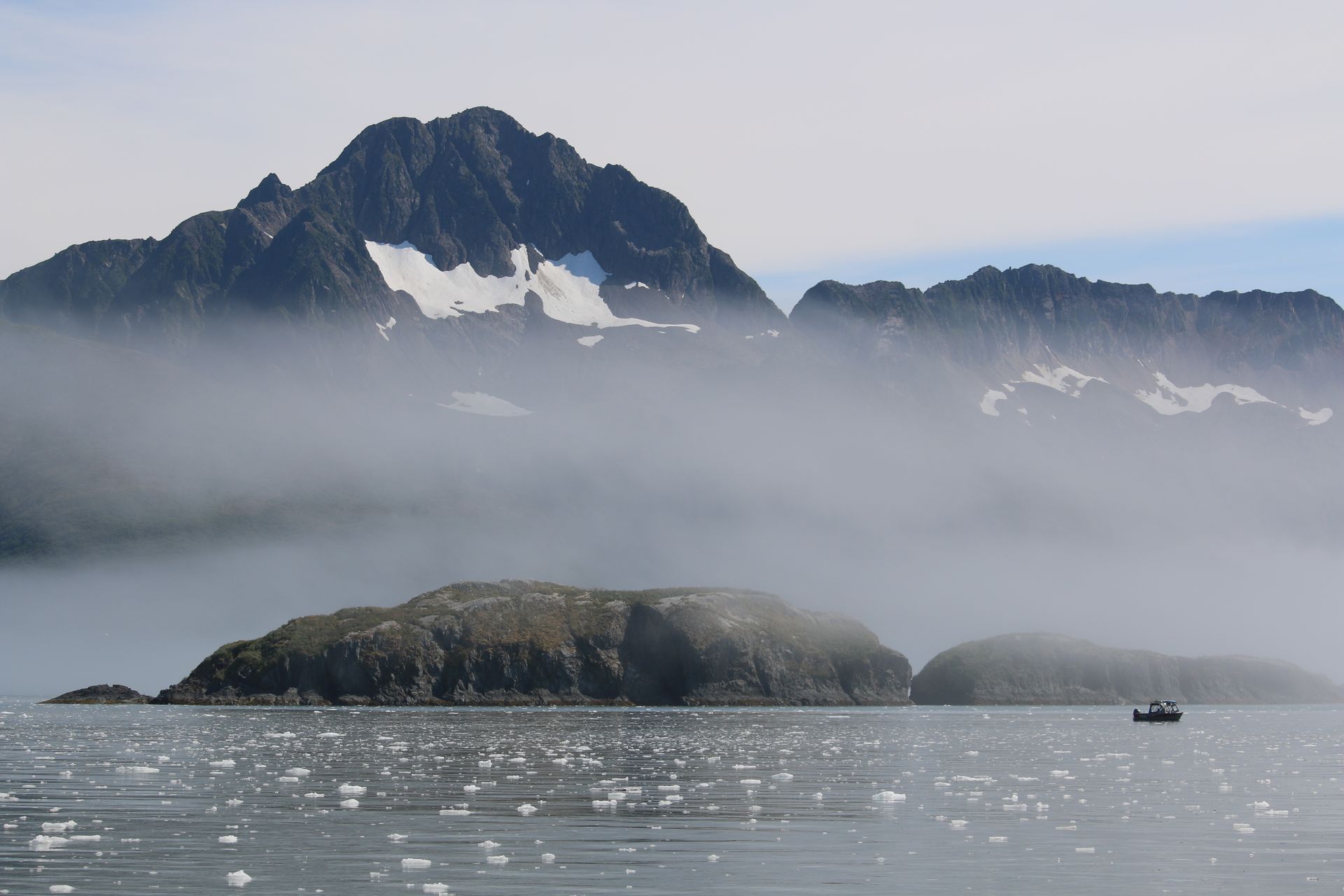 A boat in the water with mountains in the background