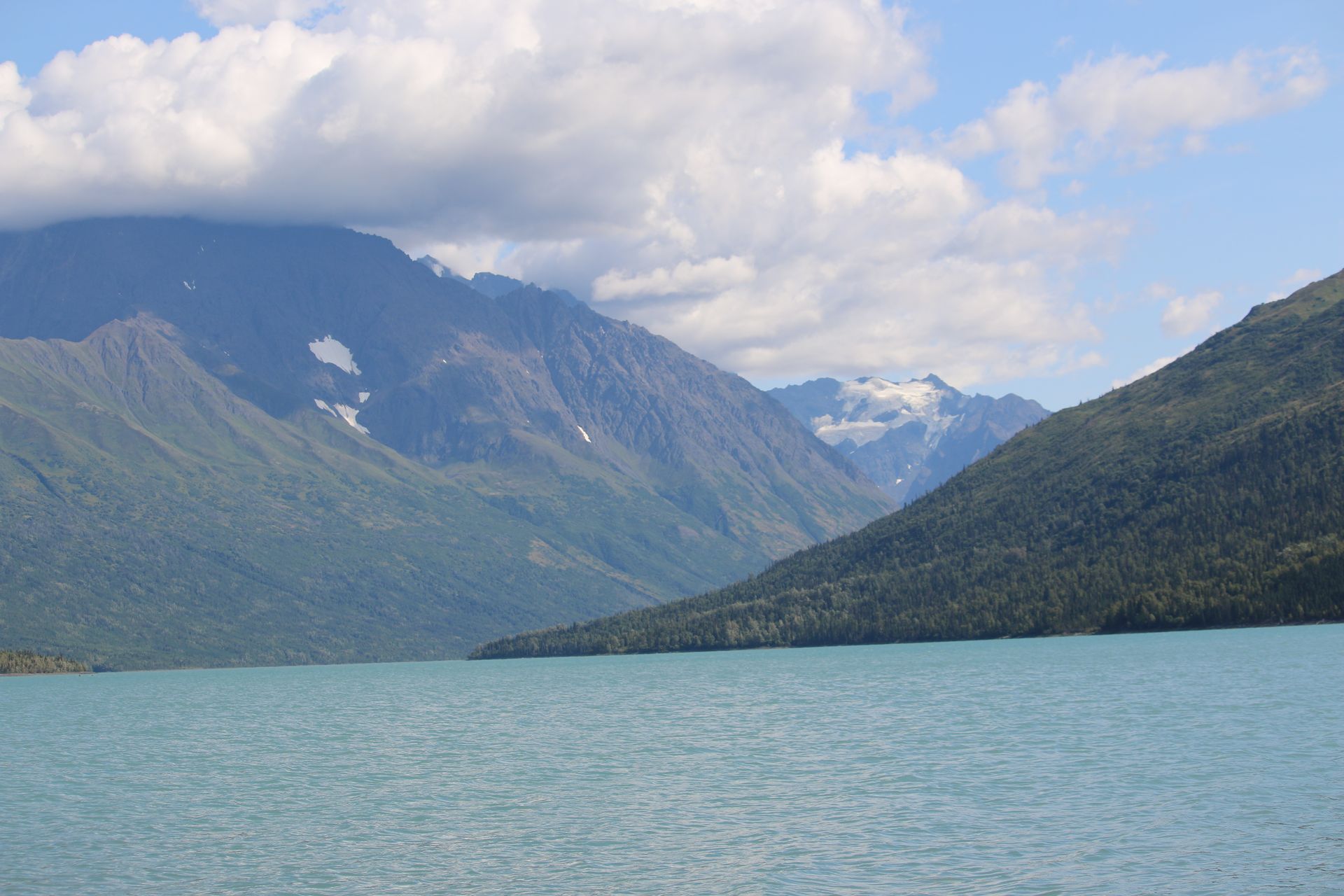 A lake with mountains in the background and trees on the shore