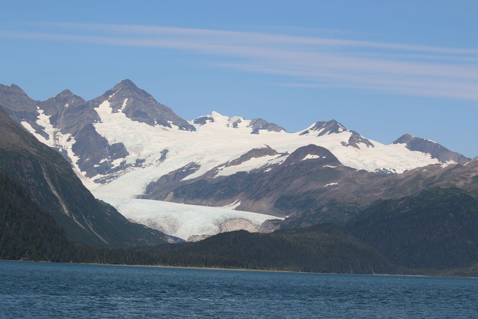 A mountain covered in snow is surrounded by a body of water