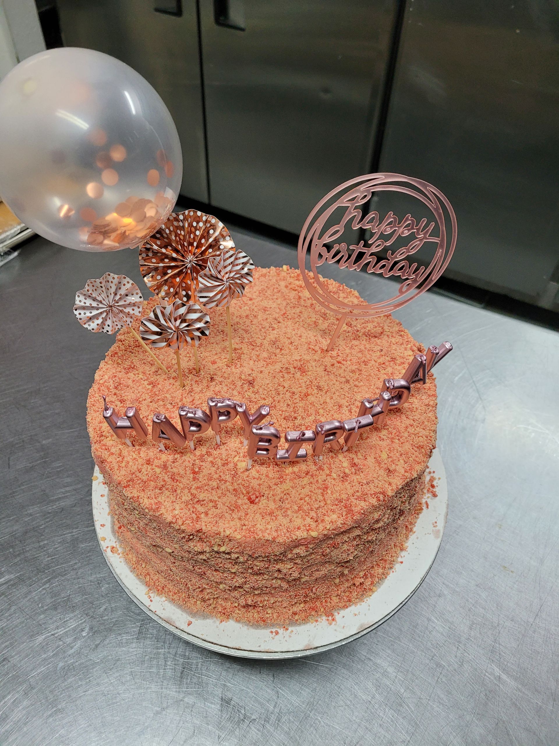 A cake with a balloon on top of it on a table.