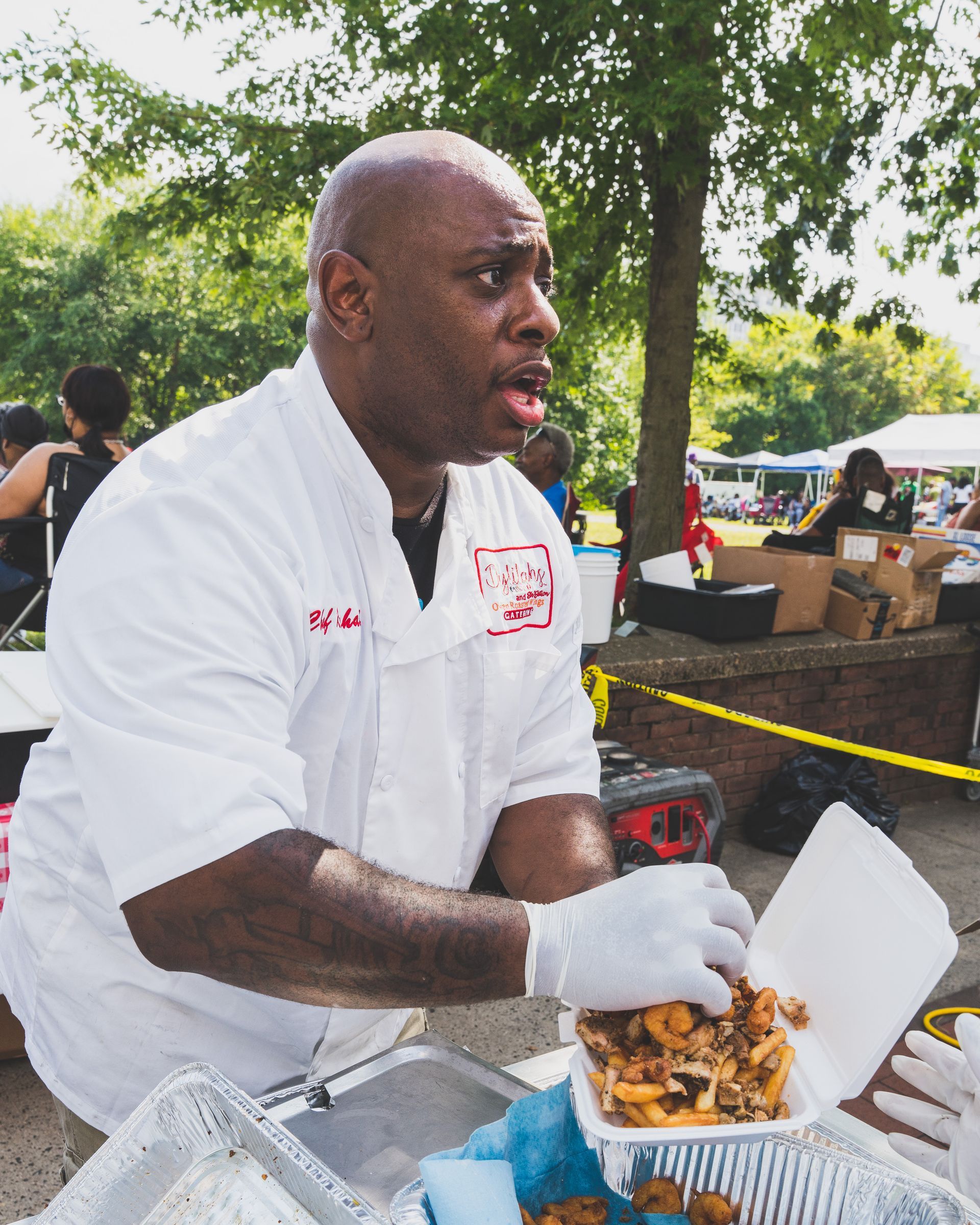 A man in a white shirt is holding a styrofoam container of food.