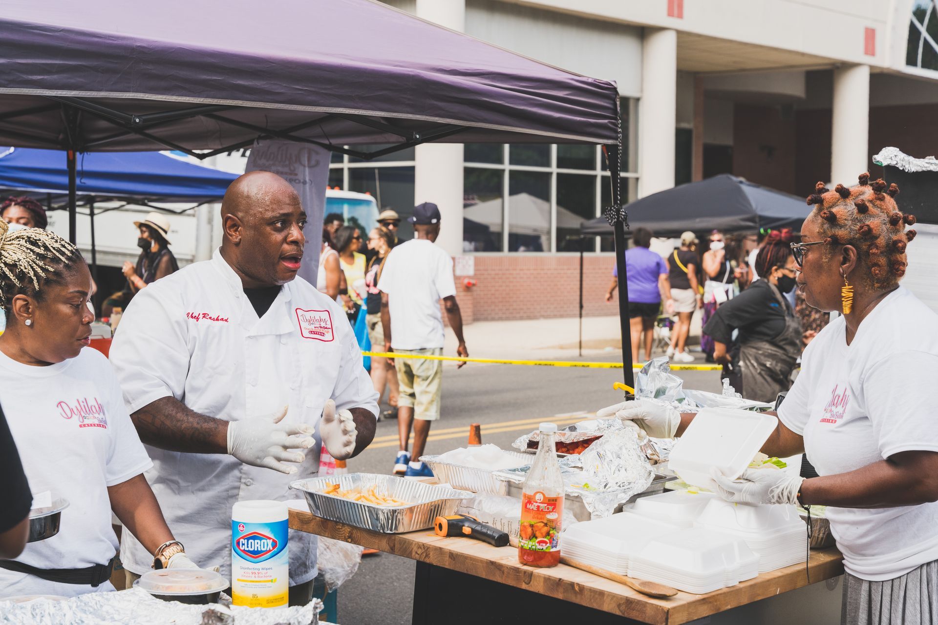 A group of people are standing around a table serving food.