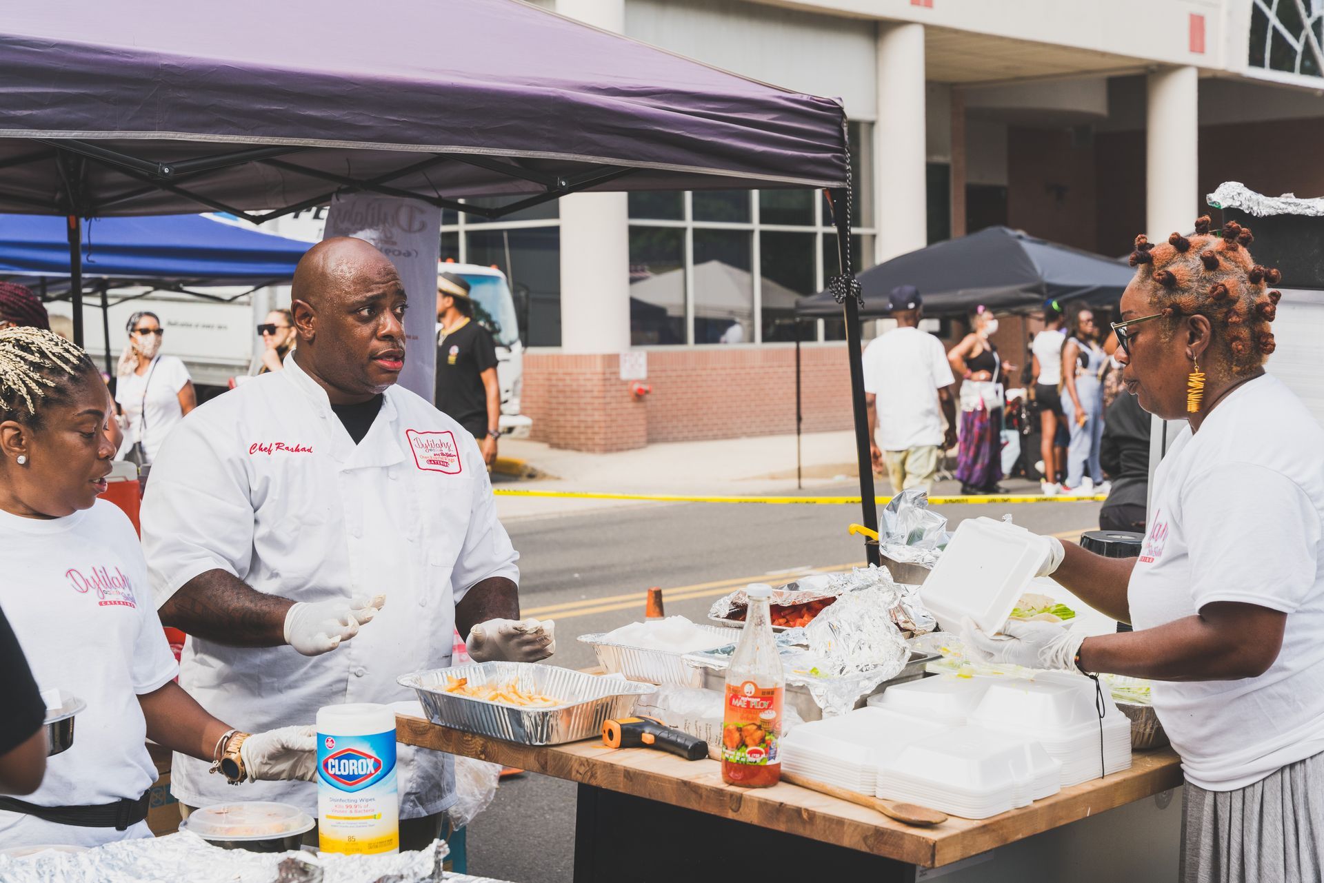 A group of people are standing around a table serving food.