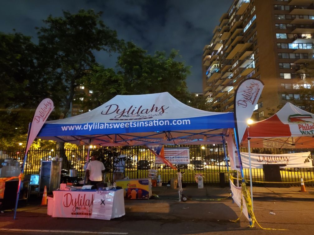 A tent with a blue awning that says ' dylilah 's ' on it