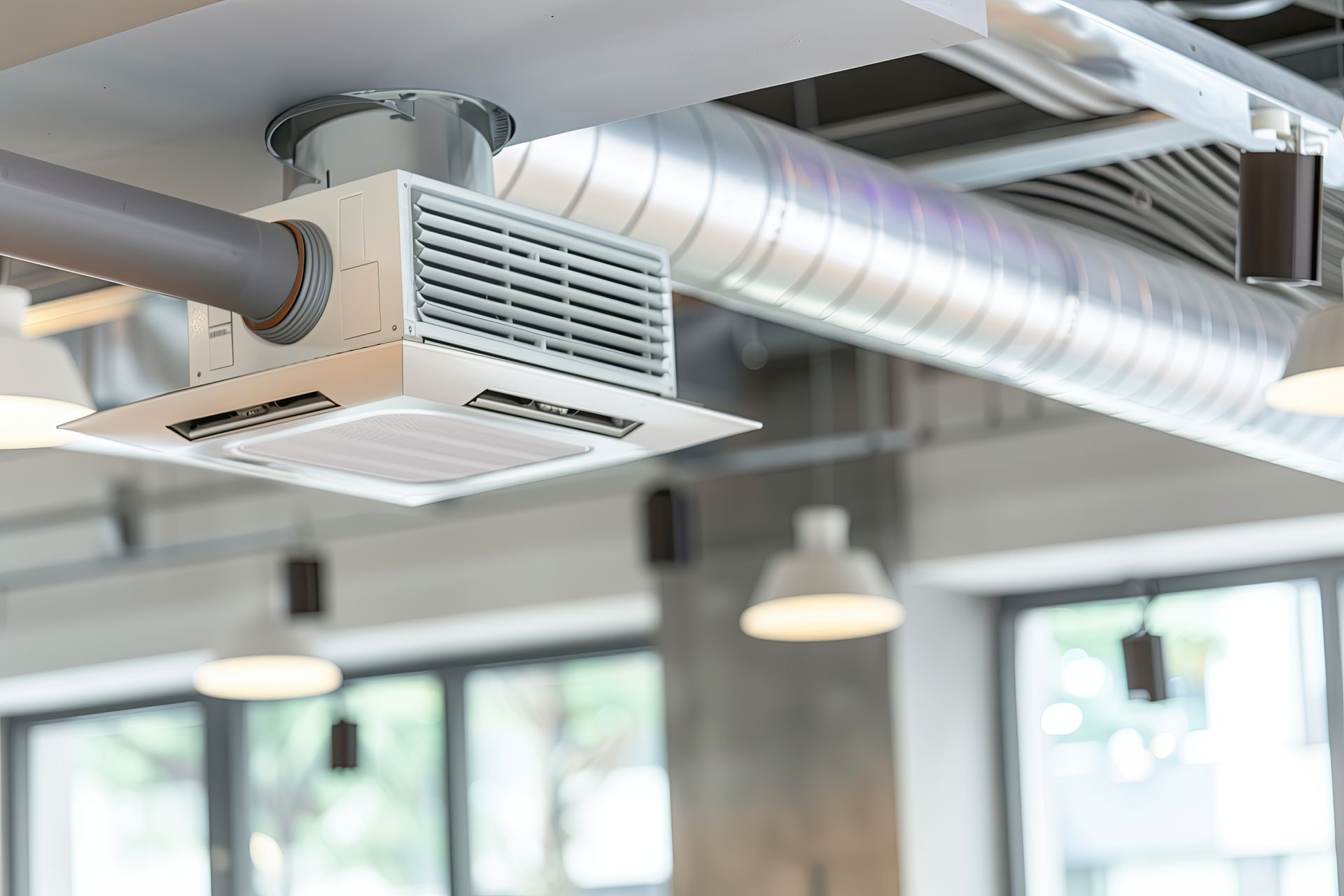 A close up of a ventilation system hanging from the ceiling of a building.
