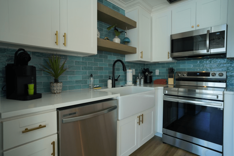 A kitchen with stainless steel appliances and white cabinets