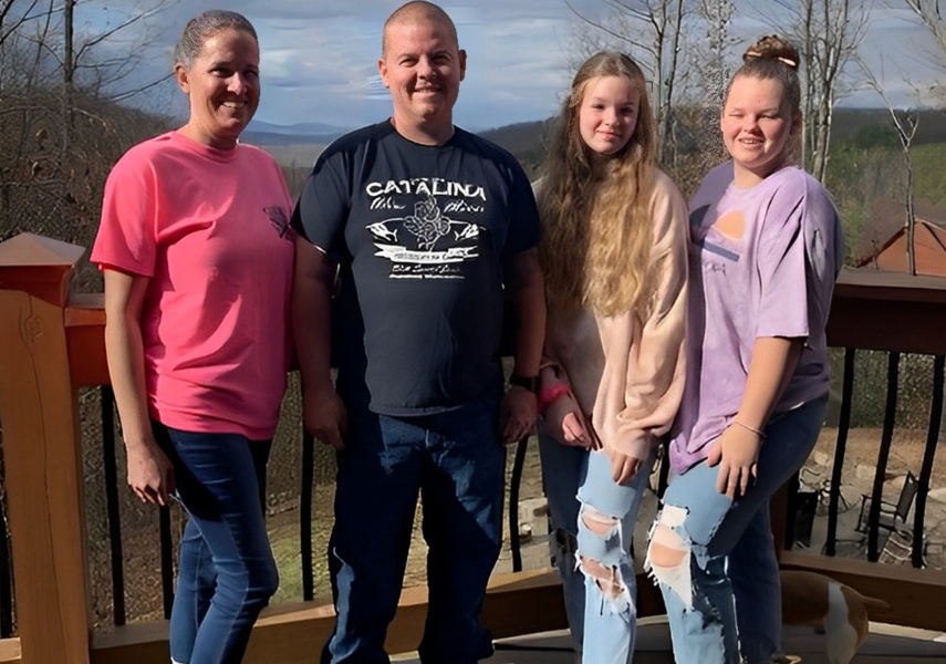 A family is posing for a picture on a balcony.