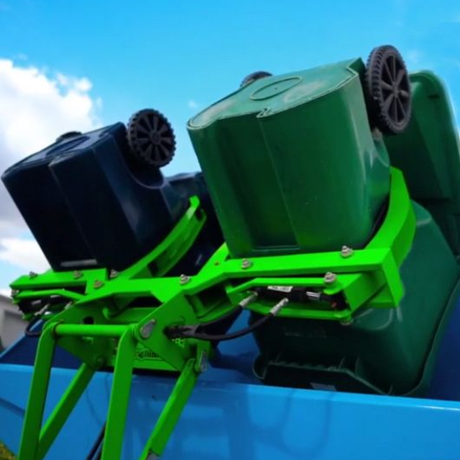 A green trash can with a piece of paper in it.