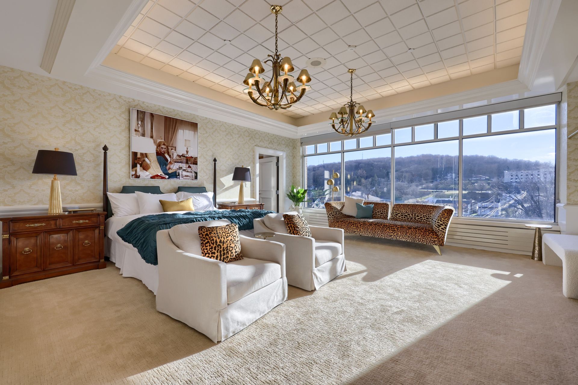 A large bedroom with a king size bed , chairs , and a couch.