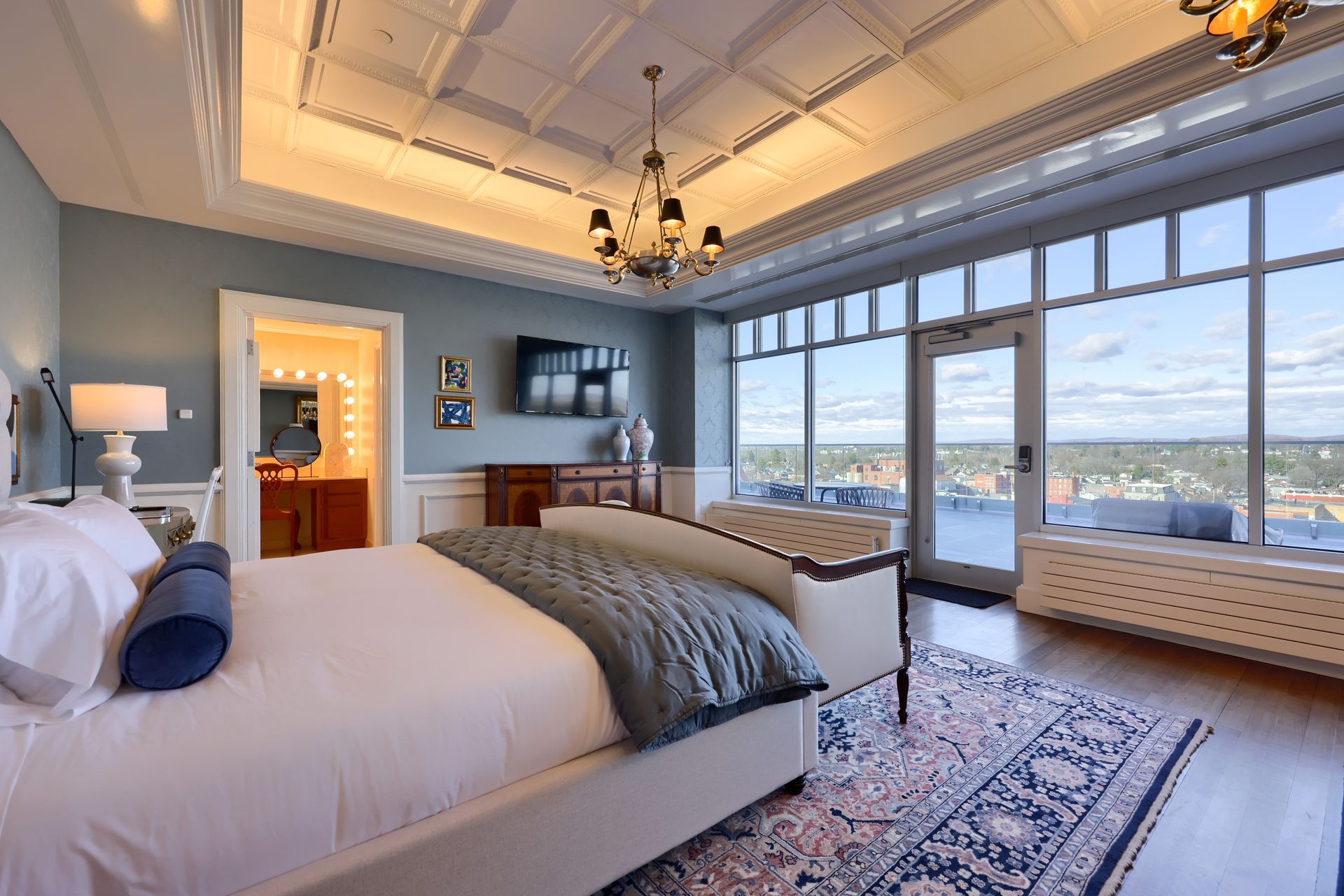 A large bedroom with a king size bed and a large window.