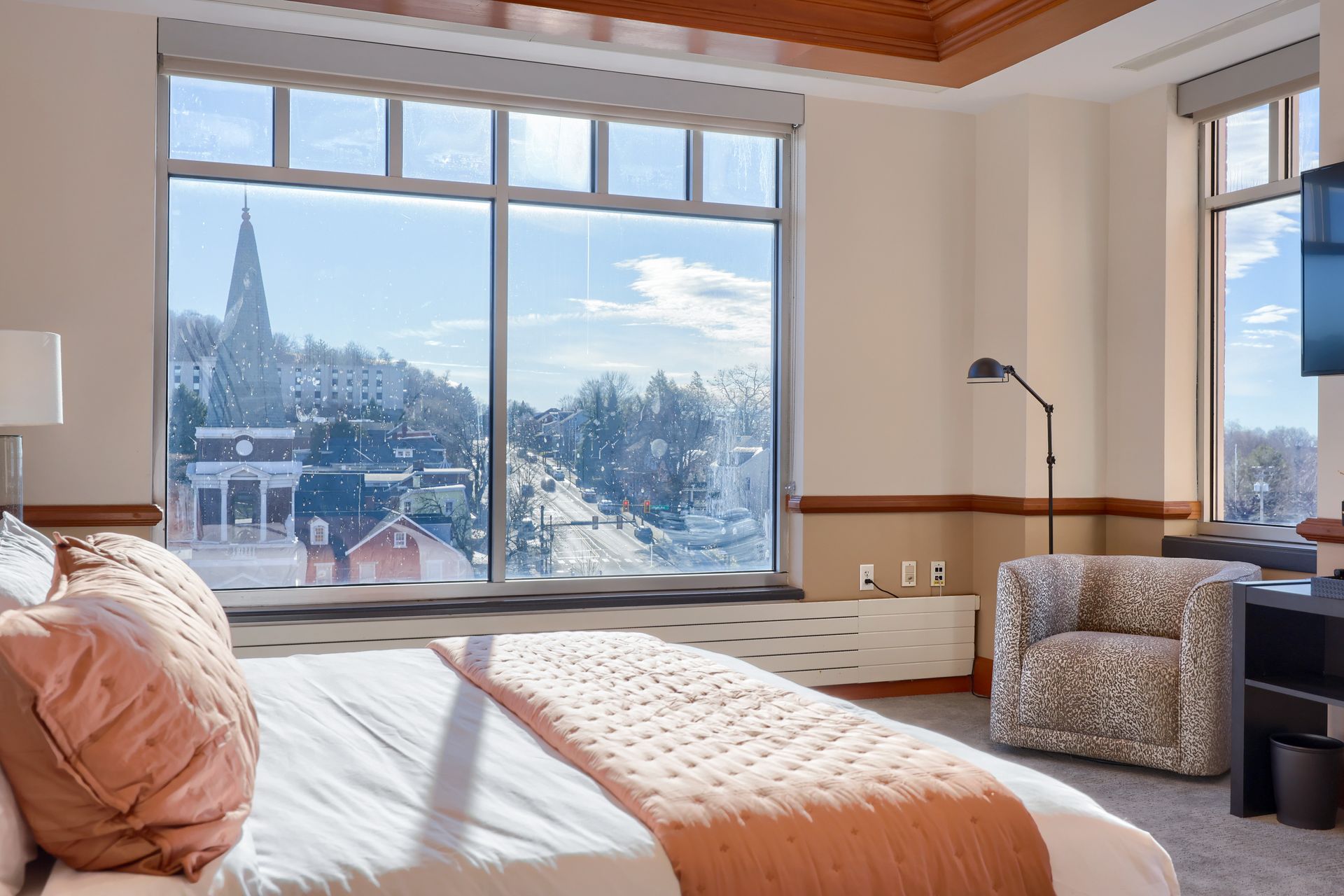 A hotel room with a large bed and a large window