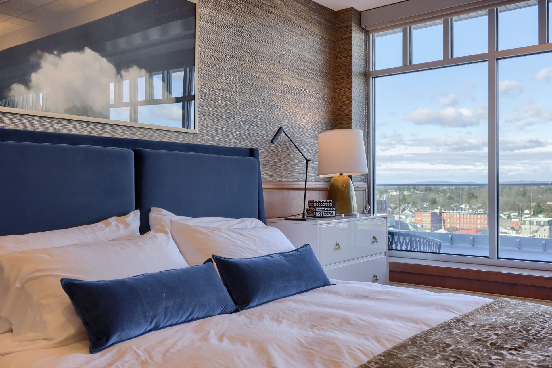 A bedroom with a large bed and a large window.
