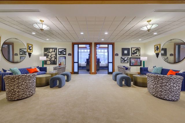 A living room with a lot of furniture and mirrors.