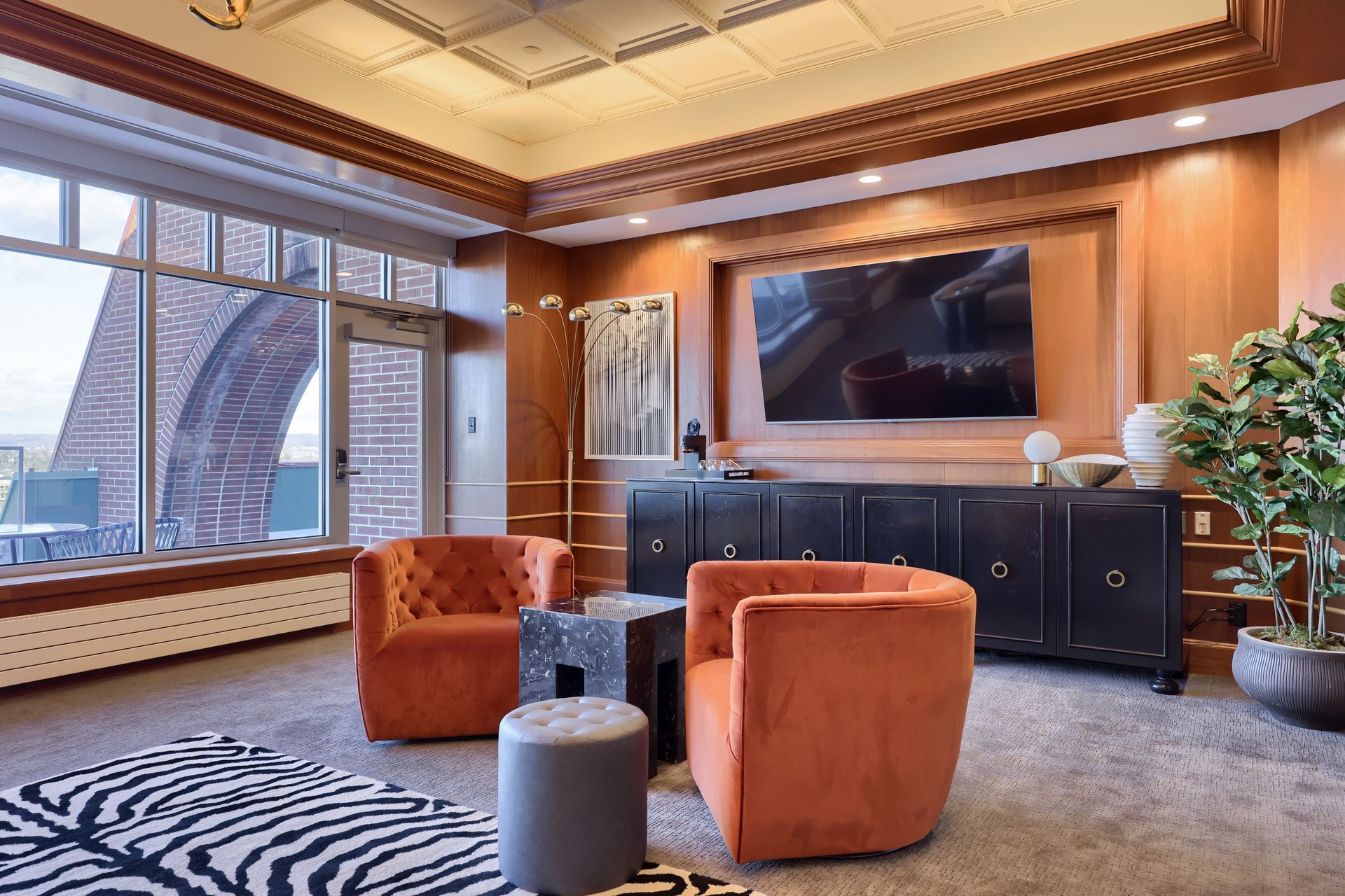 A living room with orange chairs and a flat screen tv.
