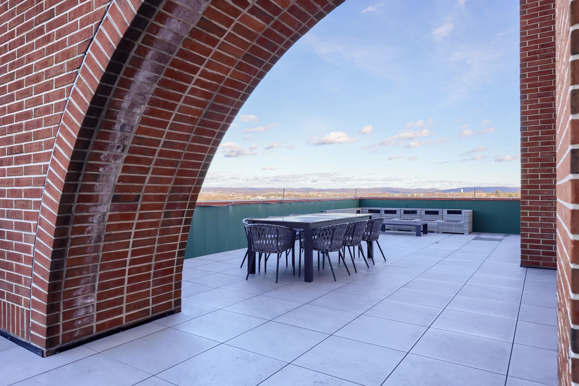 A brick building with a patio with a table and chairs on it.