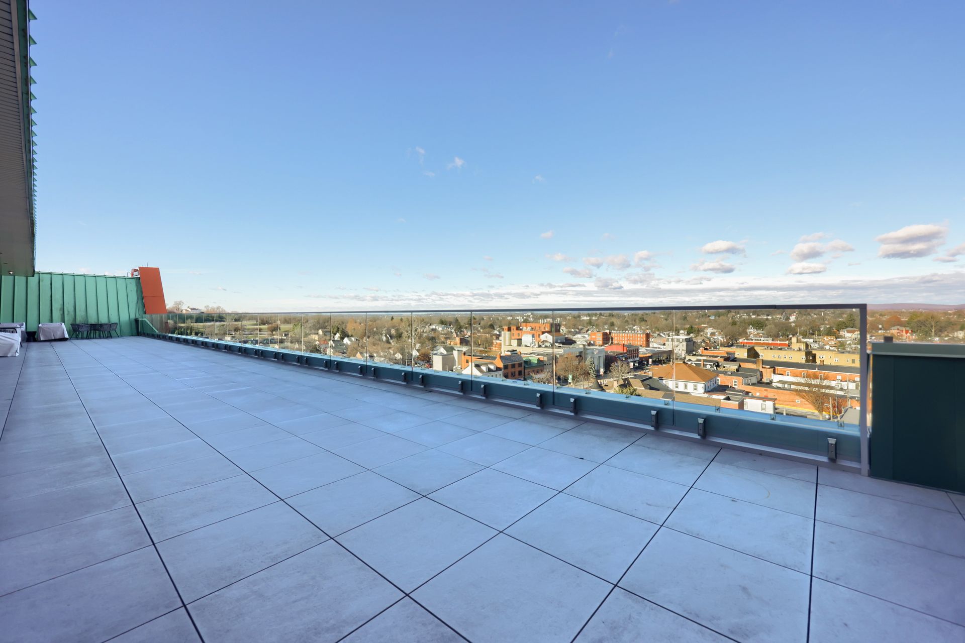 A large rooftop terrace with a view of a city.