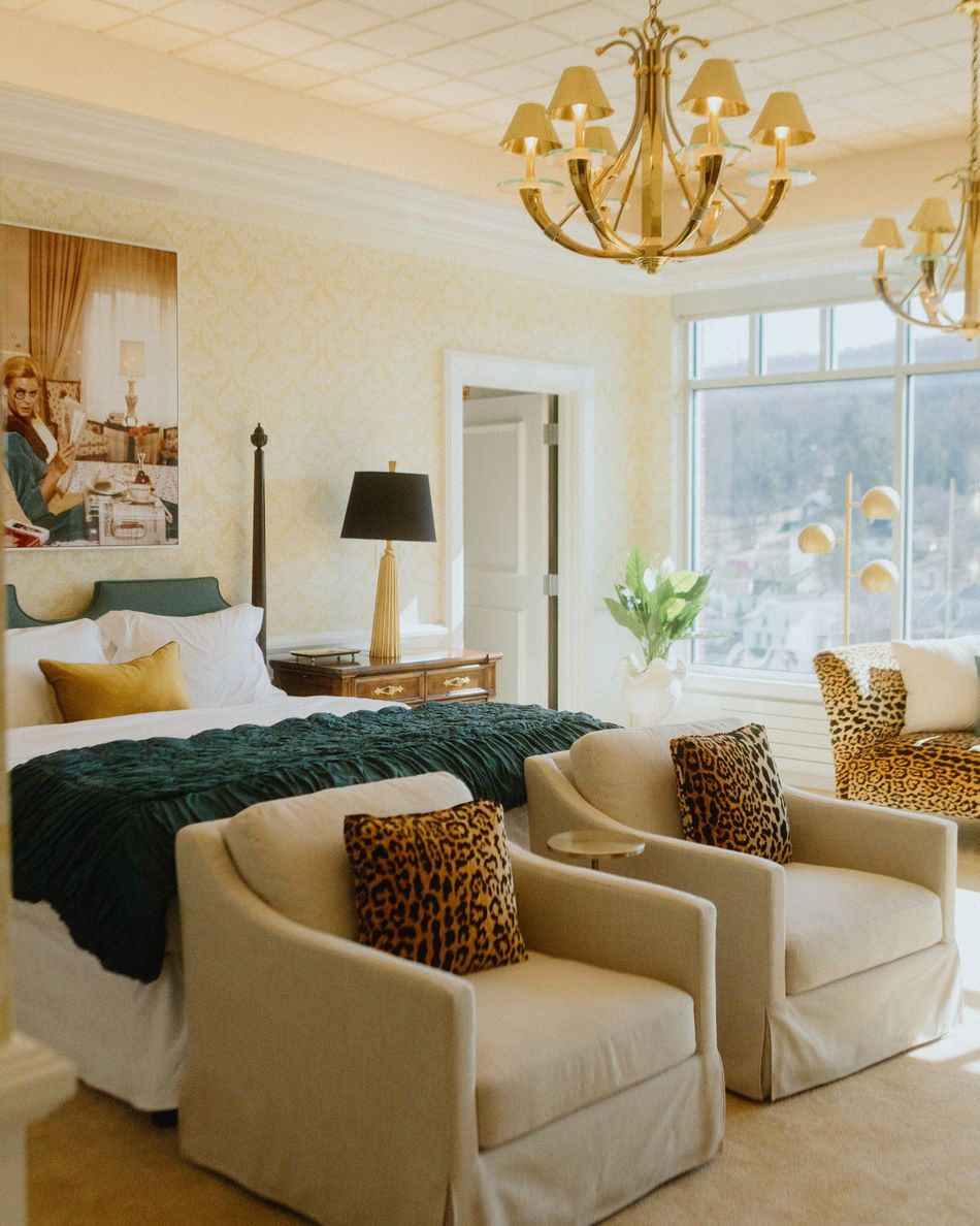 A bedroom with a large bed and a large window with a view of a city.