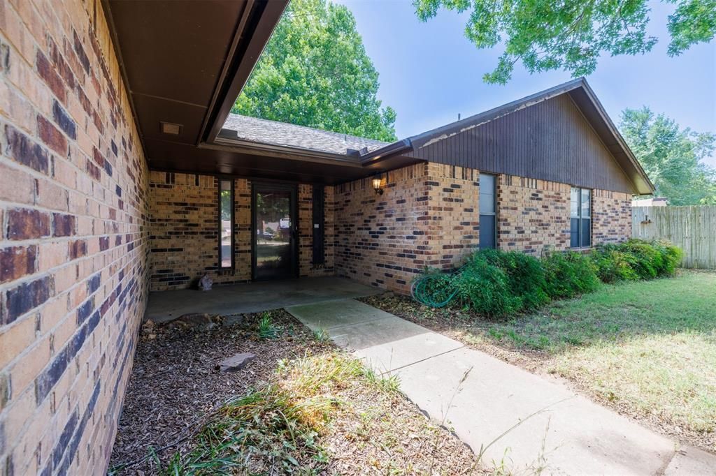 A brick house with a walkway leading to the front door.
