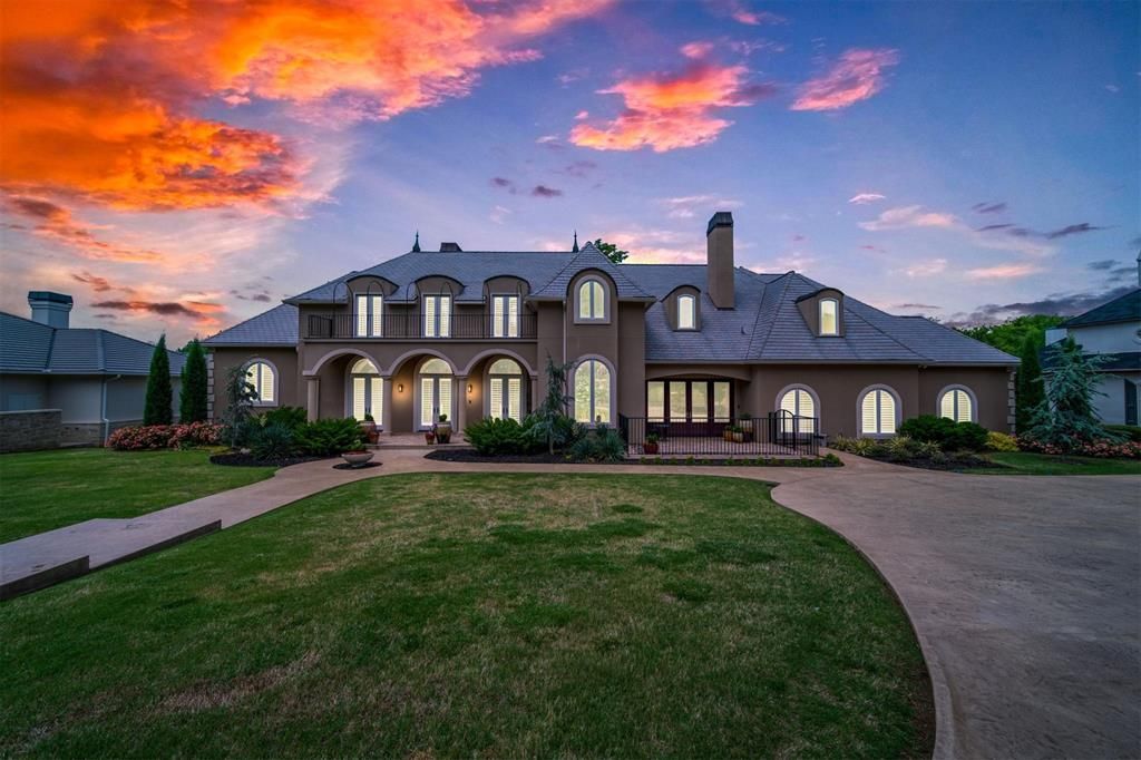 A large house with a sunset in the background is for sale.