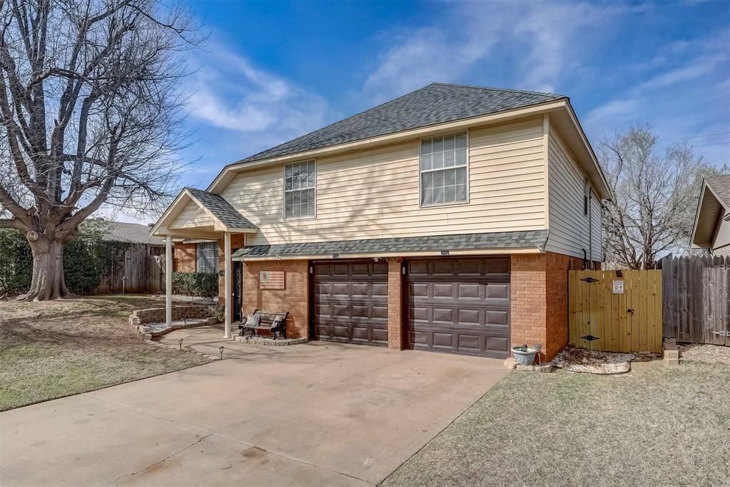 A house with two garages and a tree in front of it.