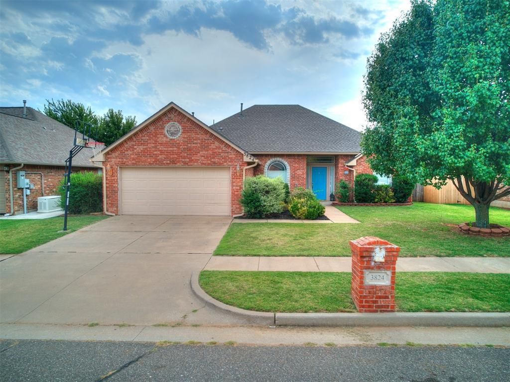 A brick house with a white garage door and a blue door