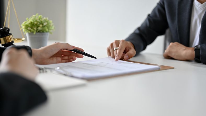 Una sala de estar con un sofá azul y dos mesas doradas.
