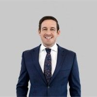 A man in a suit and tie is smiling for the camera.