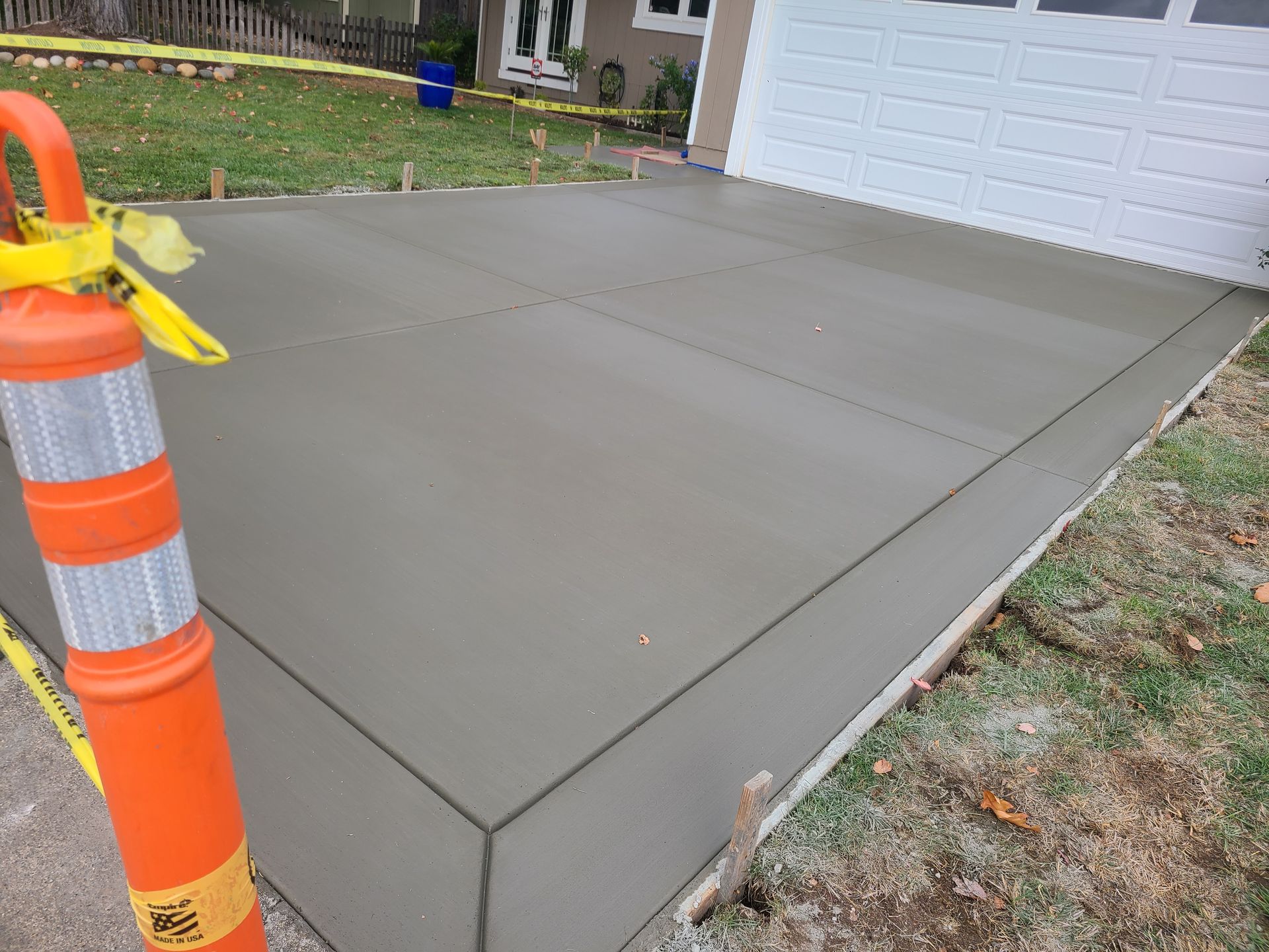 A concrete driveway is being built in front of a house.