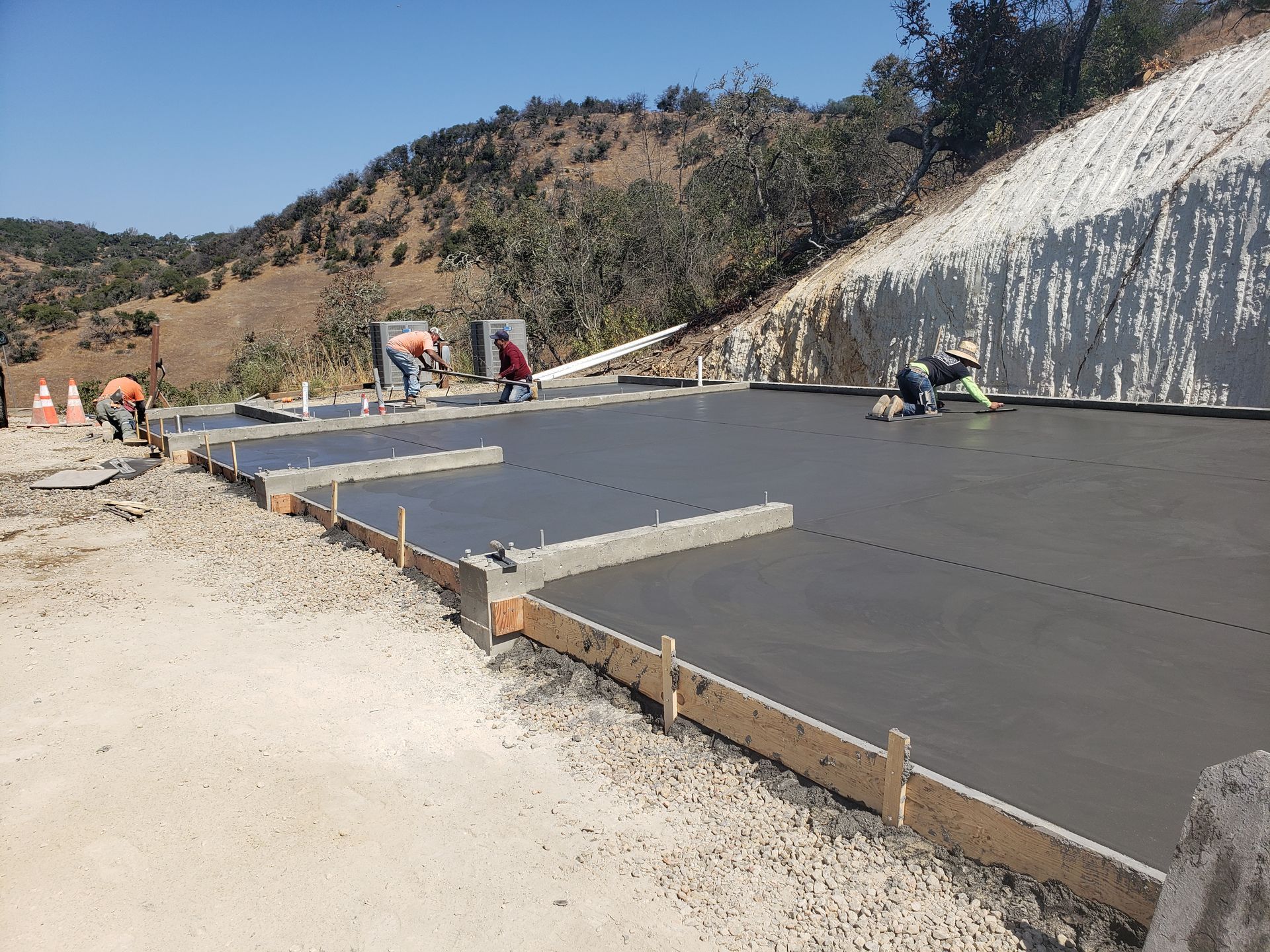 A group of construction workers are working on a concrete floor