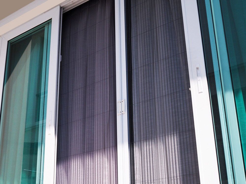 A Close Up of a Sliding Glass Door With a Screen on It — Lismore Blinds in North Lismore, NSW