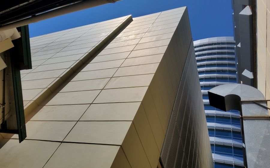 Angular Gold-toned Building Against a Bright Blue Sky — Neil Griffiths Rendering in Berry Springs, NT
