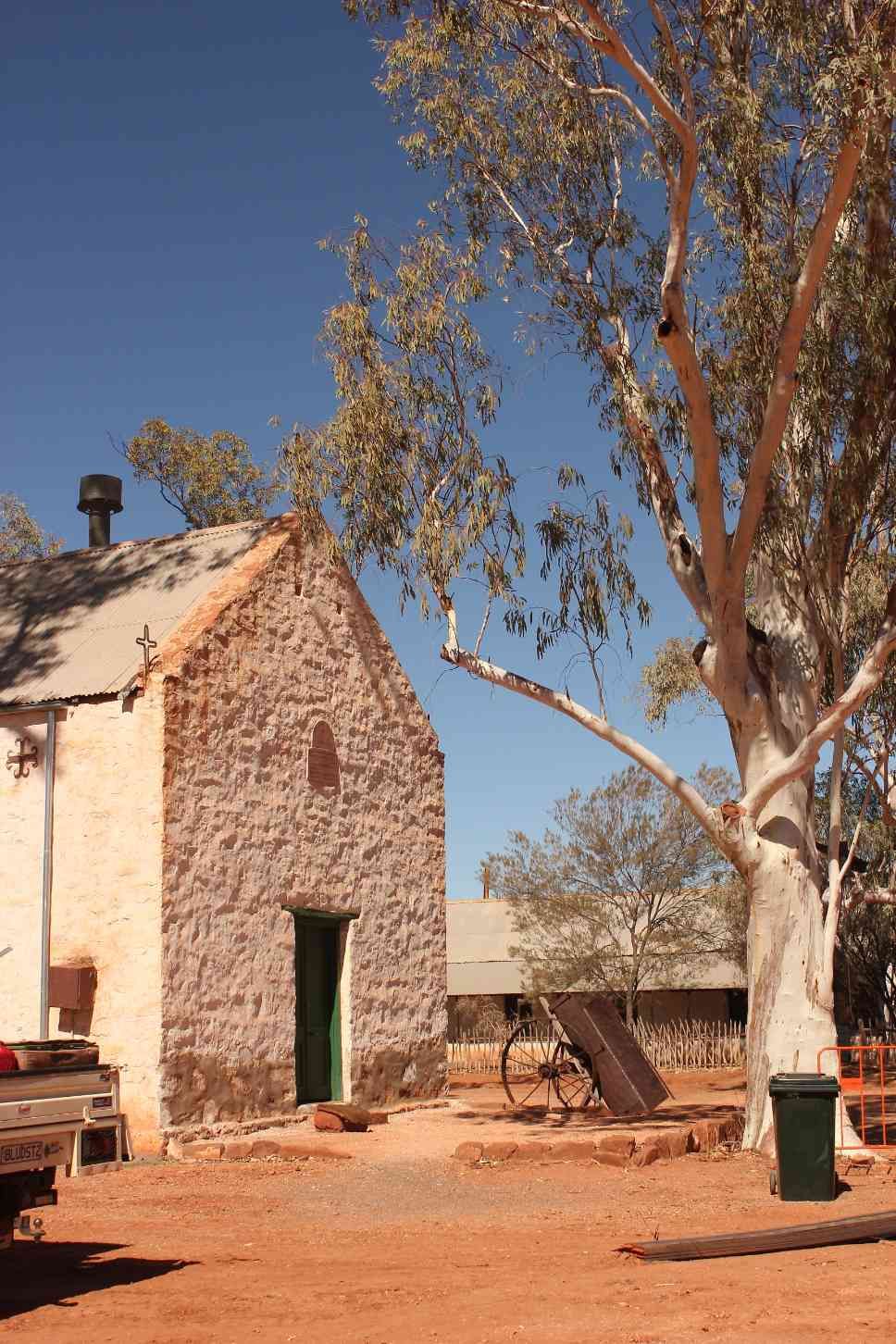 Old Stone Building With Green Door, Tall Tree, Red Dirt, and Blue Sky — Neil Griffiths Rendering in Berry Springs, NT