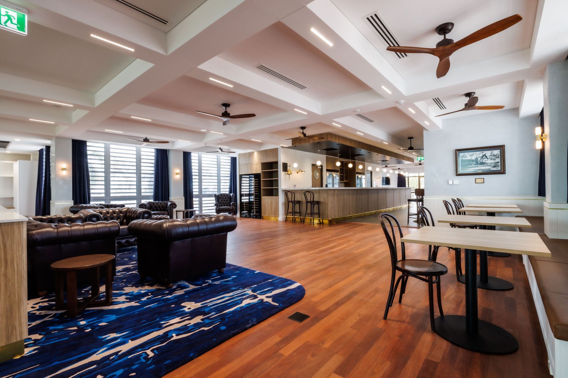 Hallway With Green Walls and Carpet Leading to a Room With People and Posters — Neil Griffiths Rendering in Berry Springs, NT
