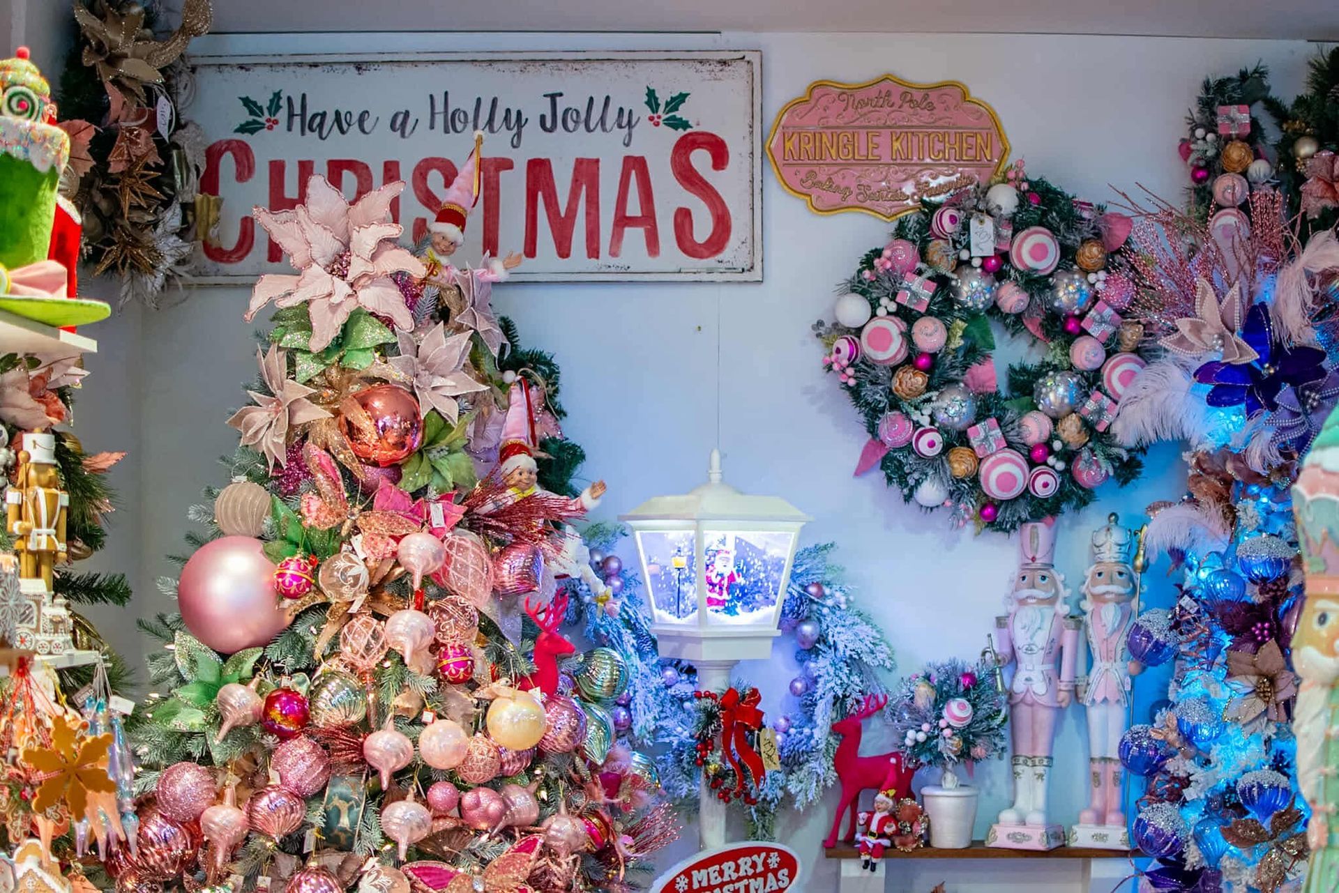 A room filled with christmas decorations and a sign that says `` have a holly jolly christmas ''.