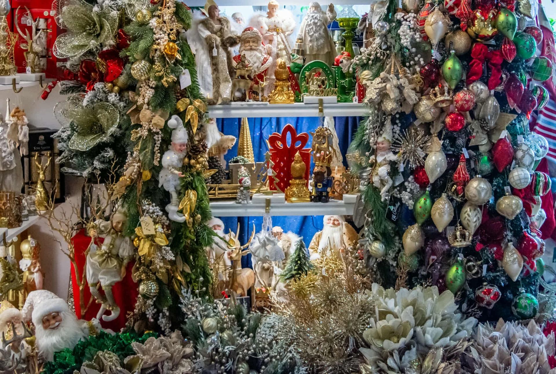A bunch of christmas decorations are sitting on a shelf in a store.