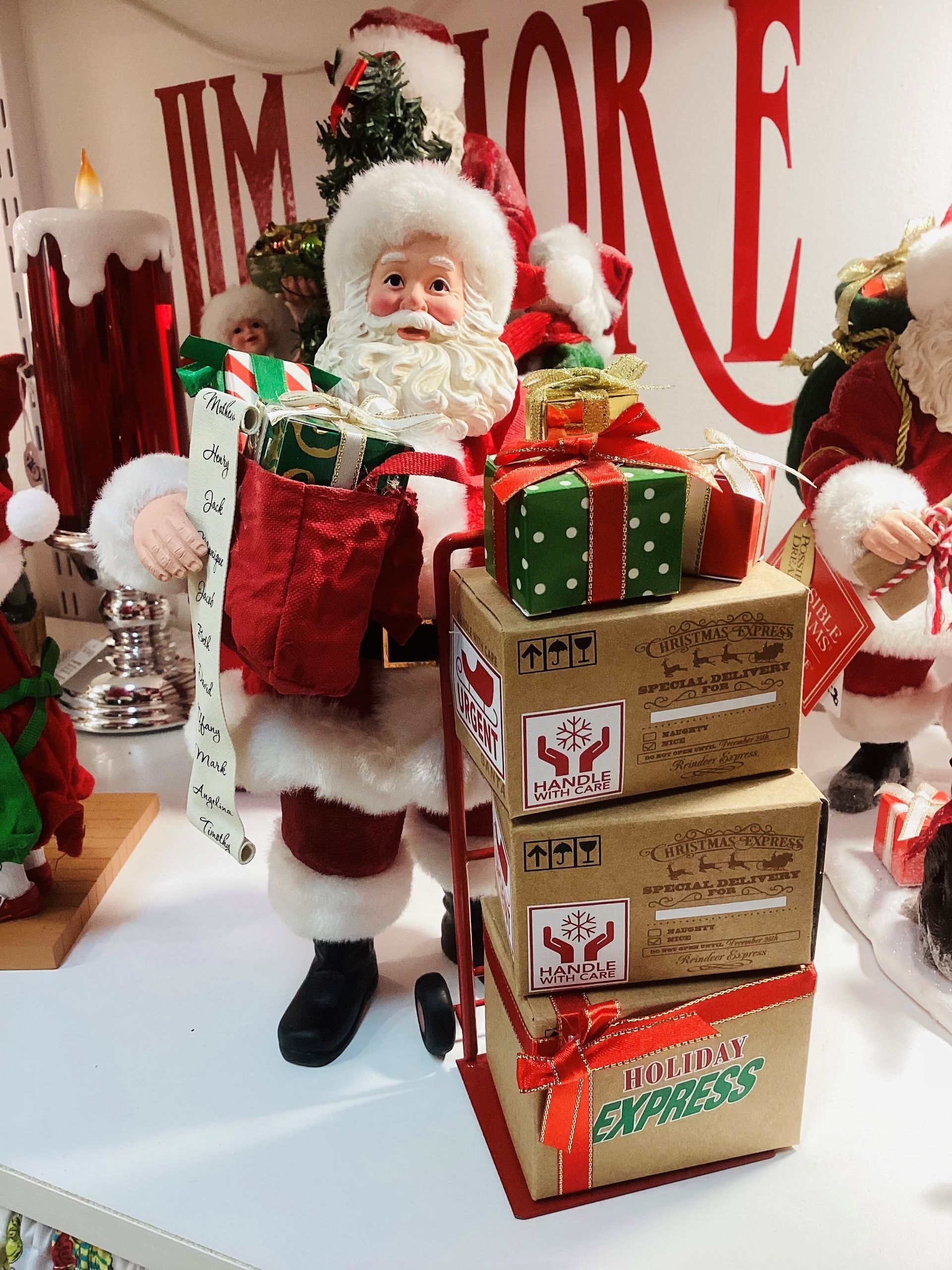 A santa claus figurine is standing next to a stack of boxes