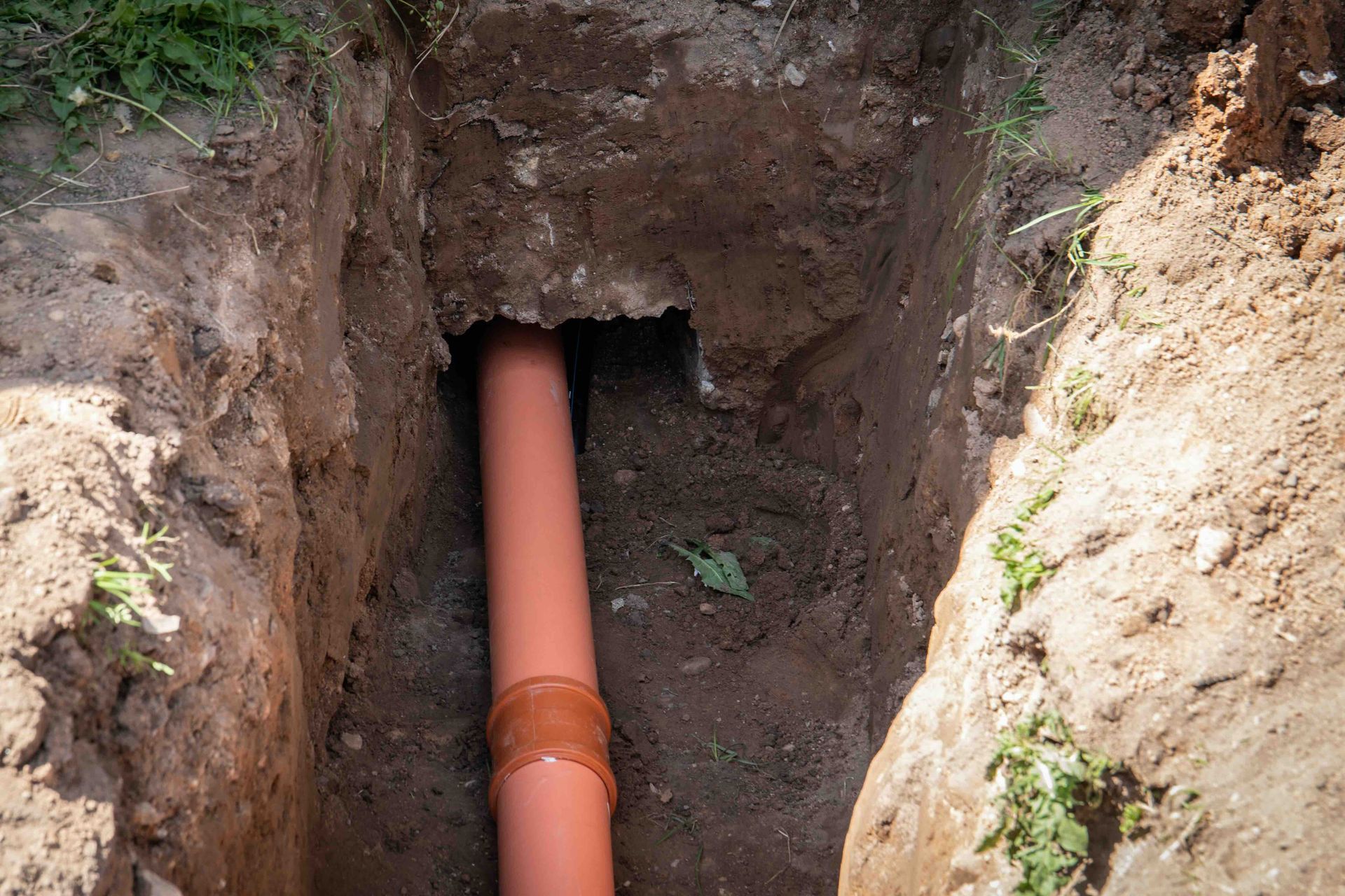 a orange pipe is in a hole in the ground.