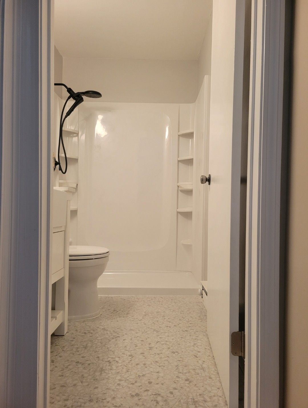 A bathroom under construction with tiles on the floor and a window.