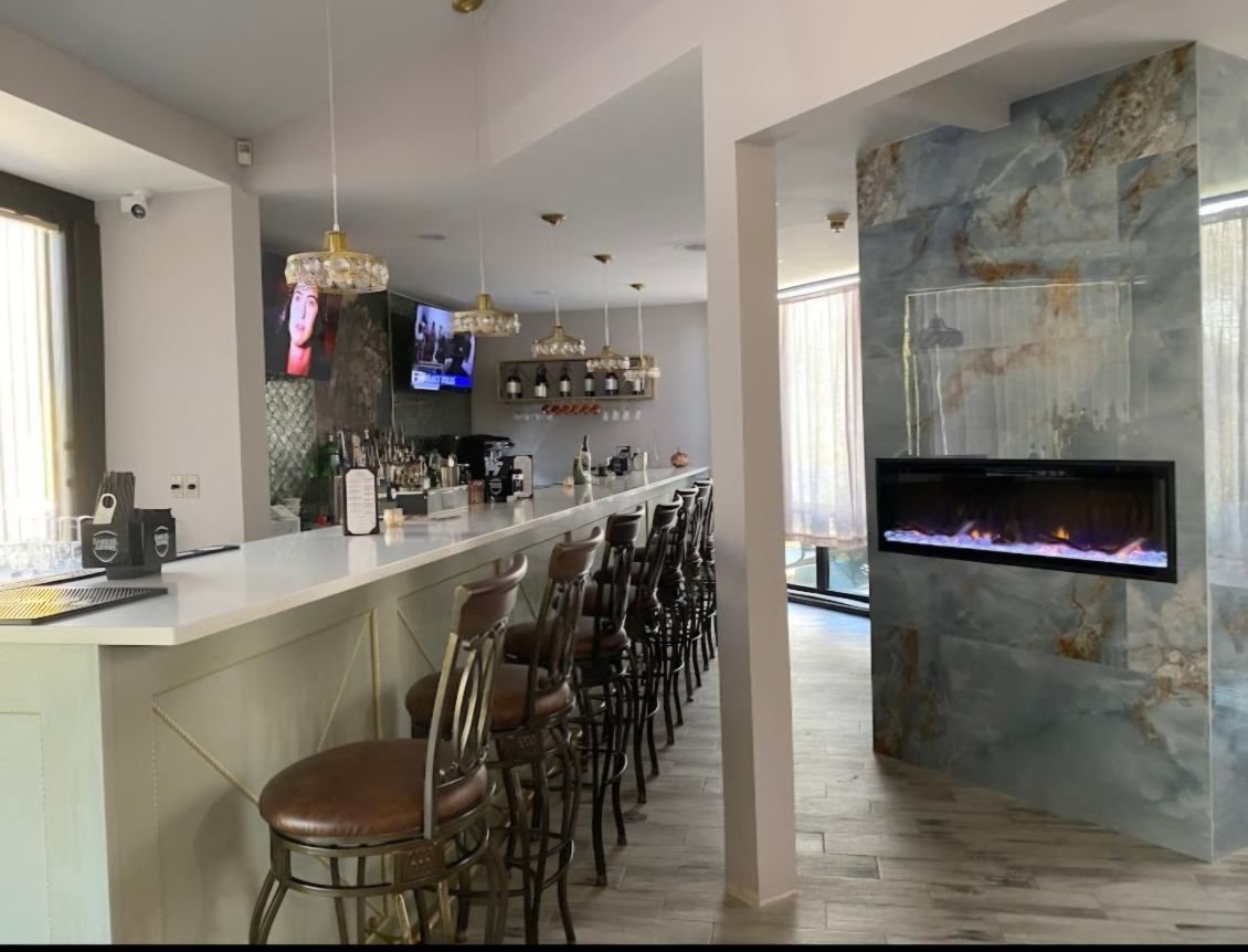 A man is measuring a piece of wood with a tape measure.