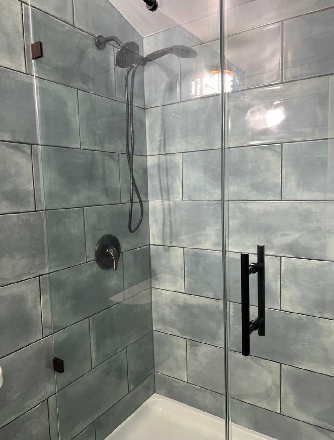 A bathroom with two sinks , a tub , and a large mirror.