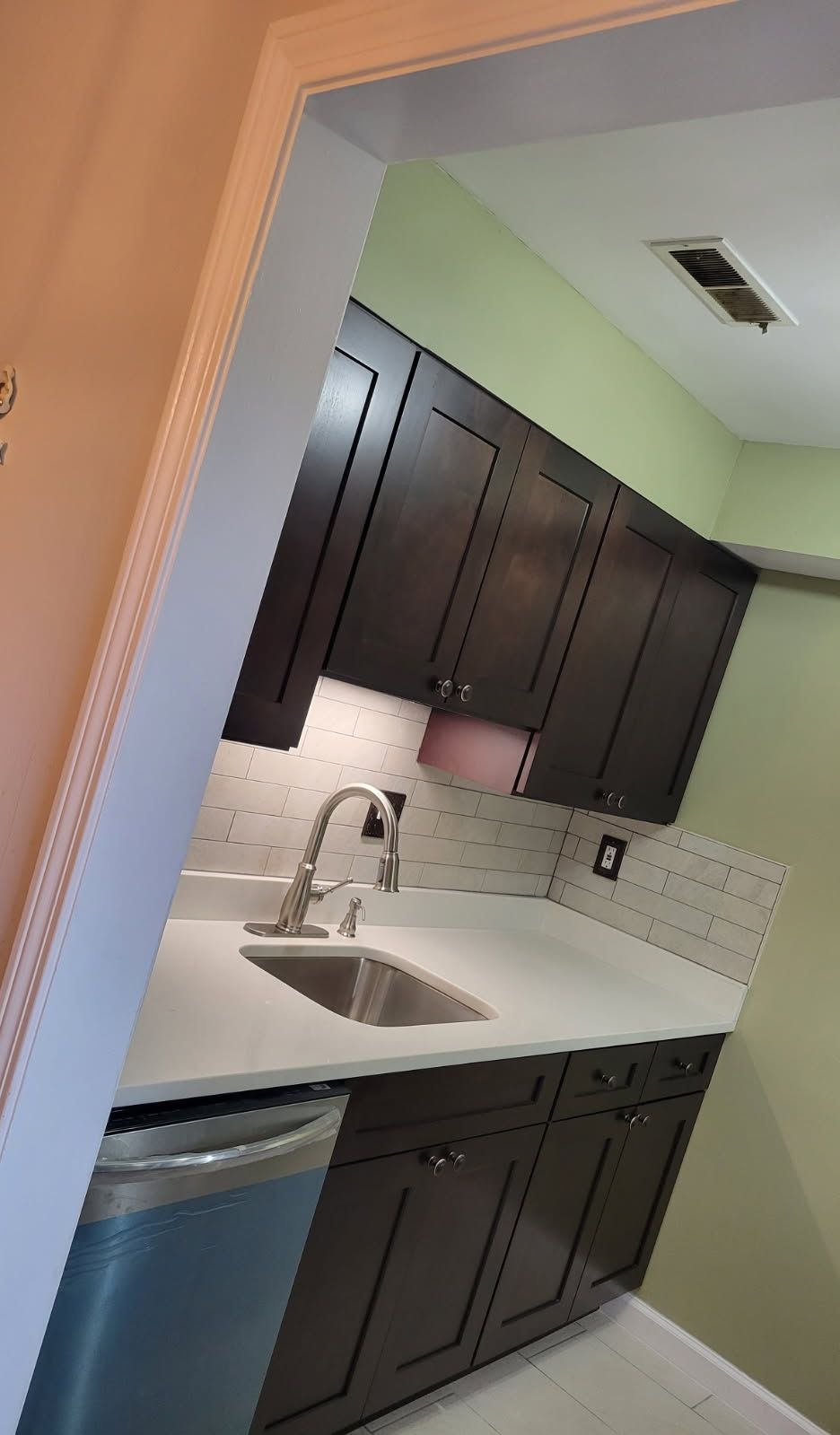 Carpenter measuring wood with a tape measure; construction site background.