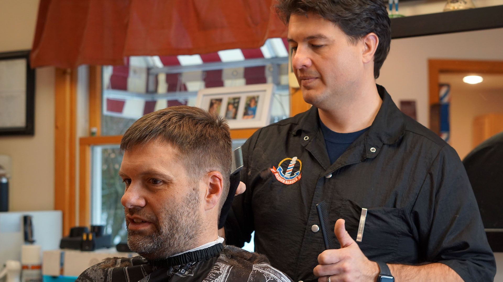 A man receives a traditional haircut from The Harbor Barber.